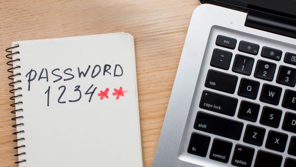 password written on paper next to computer