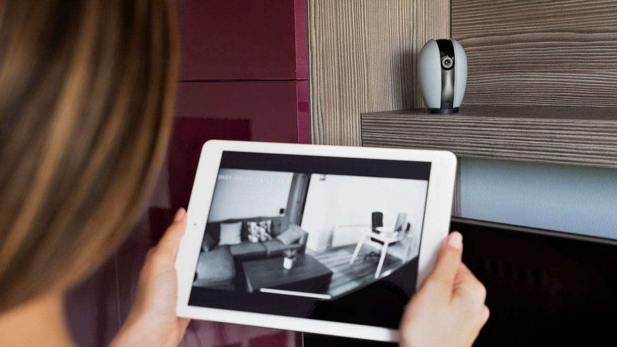 woman looking at security footage on tablet