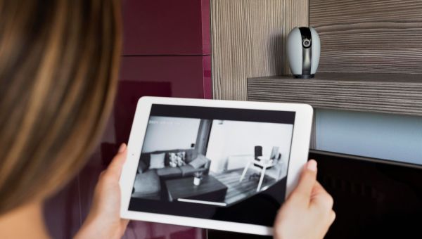 woman looking at security footage on tablet