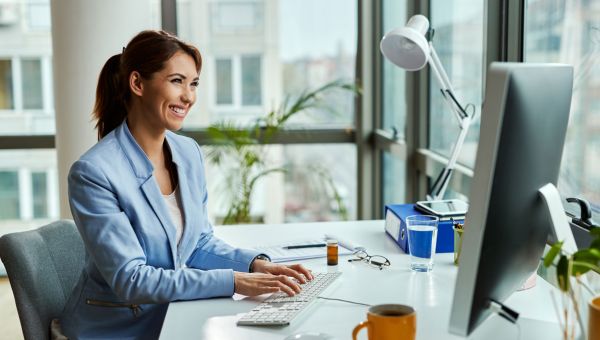 happy business woman working on computer at desk